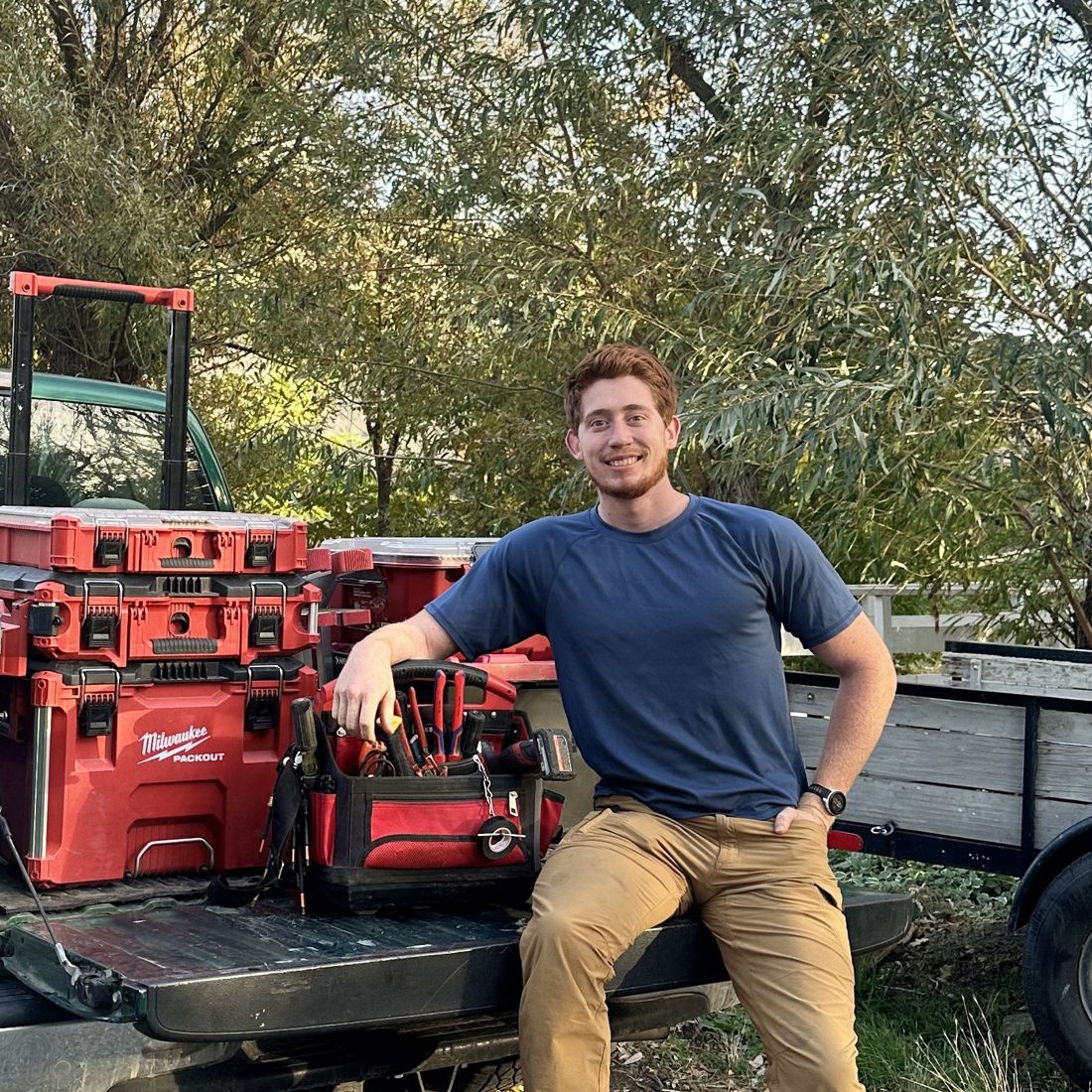 Jesse sitting on the tailgate of his truck with his tools